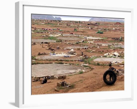 An Albanian Resident of Kukes Scavenges a Leftover Tractor Tire from a Vacant Refugee Camp-null-Framed Photographic Print