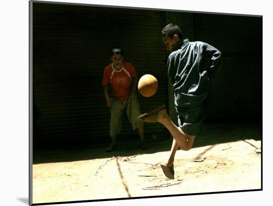 An Egyptian Boy Shows off His Ball Skill as He Plays Soccer with a Friend on the Steets of Cairo-null-Mounted Premium Photographic Print
