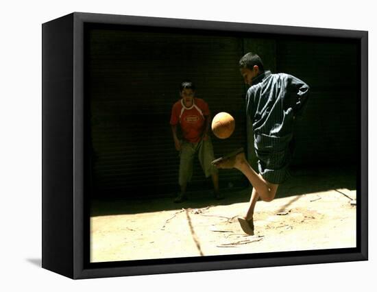 An Egyptian Boy Shows off His Ball Skill as He Plays Soccer with a Friend on the Steets of Cairo-null-Framed Stretched Canvas