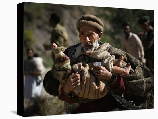 An Elderly Pakistani Earthquake Survivor Rushes Towards a Helicopter Carrying a Child in His Arms-null-Stretched Canvas