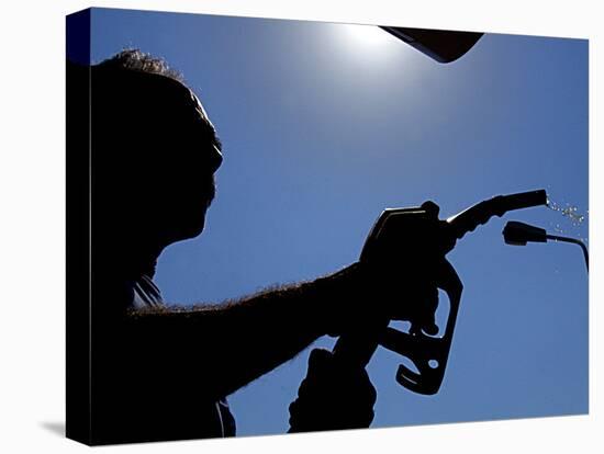 An Employee of a Petrol Station Holds a Petrol Pump after Filling up a Car-null-Stretched Canvas