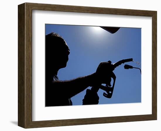 An Employee of a Petrol Station Holds a Petrol Pump after Filling up a Car-null-Framed Photographic Print