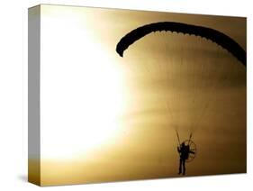 An Engine-Powered Paraglider Soars Through the Air Near Schlesen-null-Stretched Canvas