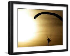 An Engine-Powered Paraglider Soars Through the Air Near Schlesen-null-Framed Photographic Print