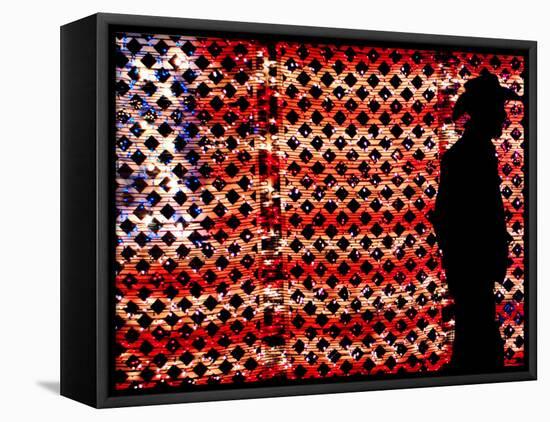 An Man Wearing a Cowboy Hat Walks Past an American Flag Light Display-Brandi Simons-Framed Stretched Canvas