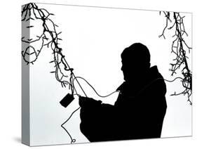 An Man Wires Christmas Lights-null-Stretched Canvas