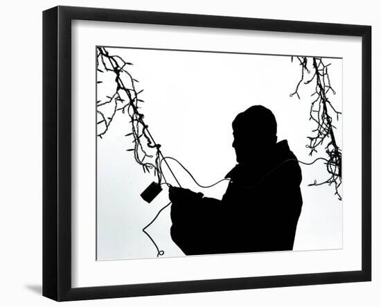 An Man Wires Christmas Lights-null-Framed Photographic Print