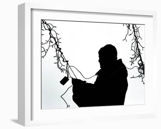 An Man Wires Christmas Lights-null-Framed Photographic Print