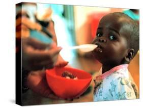 An Unidentified Baby is Fed at a Home for Hiv/Aids and Abandoned Children-null-Stretched Canvas