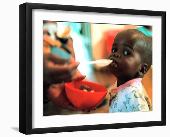An Unidentified Baby is Fed at a Home for Hiv/Aids and Abandoned Children-null-Framed Premium Photographic Print