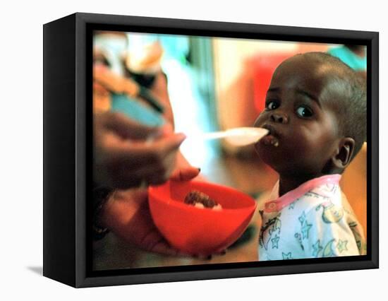 An Unidentified Baby is Fed at a Home for Hiv/Aids and Abandoned Children-null-Framed Stretched Canvas