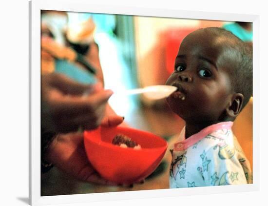 An Unidentified Baby is Fed at a Home for Hiv/Aids and Abandoned Children-null-Framed Photographic Print