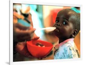 An Unidentified Baby is Fed at a Home for Hiv/Aids and Abandoned Children-null-Framed Photographic Print