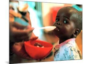 An Unidentified Baby is Fed at a Home for Hiv/Aids and Abandoned Children-null-Mounted Photographic Print