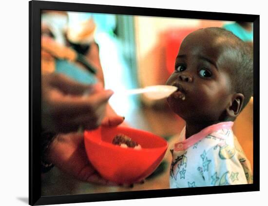 An Unidentified Baby is Fed at a Home for Hiv/Aids and Abandoned Children-null-Framed Photographic Print