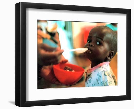 An Unidentified Baby is Fed at a Home for Hiv/Aids and Abandoned Children-null-Framed Photographic Print