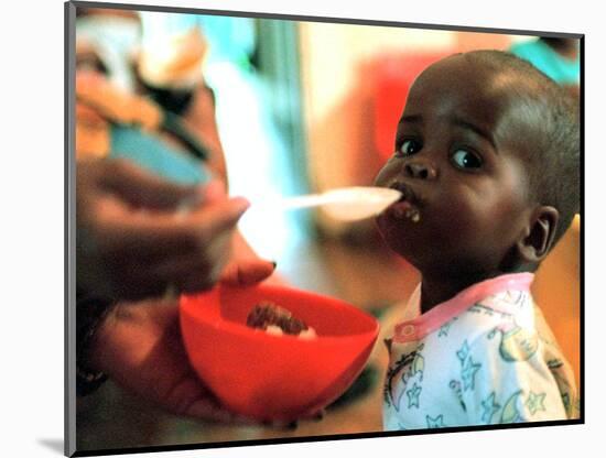 An Unidentified Baby is Fed at a Home for Hiv/Aids and Abandoned Children-null-Mounted Photographic Print