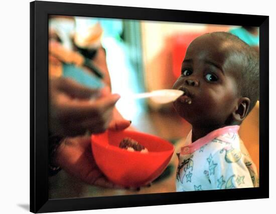 An Unidentified Baby is Fed at a Home for Hiv/Aids and Abandoned Children-null-Framed Photographic Print