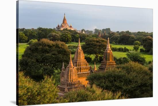 Ancient temple and pagoda rising out of the jungle at sunrise, Bagan, Mandalay Region, Myanmar-Keren Su-Stretched Canvas