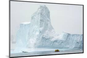 Antarctica. Charlotte Bay. Zodiac Dwarfed by a Giant Towering Iceberg-Inger Hogstrom-Mounted Photographic Print