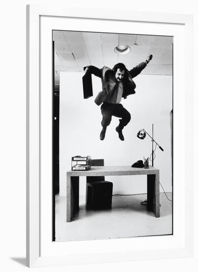 Architect and Designer Frank Gehry Jumping on a Desk in His Line of Cardboard Furniture-Ralph Morse-Framed Photographic Print