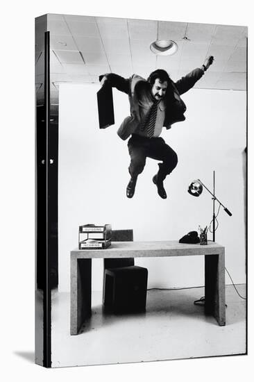 Architect and Designer Frank Gehry Jumping on a Desk in His Line of Cardboard Furniture-Ralph Morse-Stretched Canvas