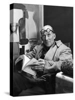 Architect Le Corbusier Sitting in Chair and Holding Book in Hands-Nina Leen-Stretched Canvas