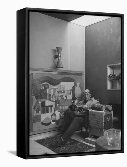 Architect Le Corbusier Sitting in Chair with Book in Hands, Glasses Perched on His Forehead-Nina Leen-Framed Stretched Canvas