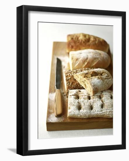 Assorted Loaves on Wooden Chopping Board-Michael Paul-Framed Photographic Print