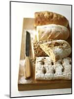 Assorted Loaves on Wooden Chopping Board-Michael Paul-Mounted Photographic Print