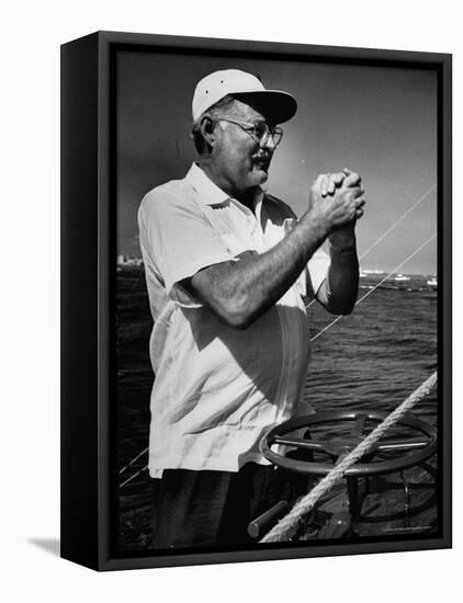 Author Ernest Hemingway at Wheel of Fishing Boat During Fishing Tournament-Alfred Eisenstaedt-Framed Stretched Canvas