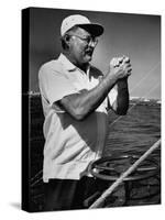 Author Ernest Hemingway at Wheel of Fishing Boat During Fishing Tournament-Alfred Eisenstaedt-Stretched Canvas