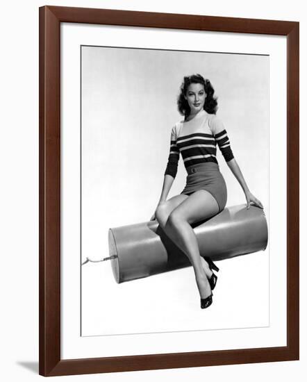 Ava Gardner seated on Giant firecracker, c. 1945 (b/w photo)-null-Framed Photo