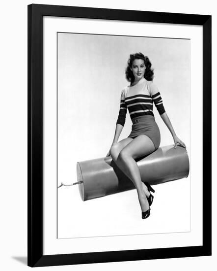 Ava Gardner seated on Giant firecracker, c. 1945 (b/w photo)-null-Framed Photo