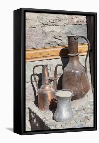 Azerbaijan, Lahic. A copper kettle and jug sitting outside a residence.-Alida Latham-Framed Stretched Canvas