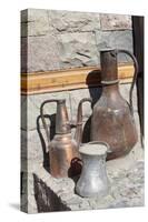 Azerbaijan, Lahic. A copper kettle and jug sitting outside a residence.-Alida Latham-Stretched Canvas