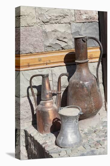 Azerbaijan, Lahic. A copper kettle and jug sitting outside a residence.-Alida Latham-Stretched Canvas