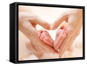Baby Feet in Mother Hands. Tiny Newborn Baby's Feet on Female Heart Shaped Hands Closeup. Mom and H-Subbotina Anna-Framed Stretched Canvas