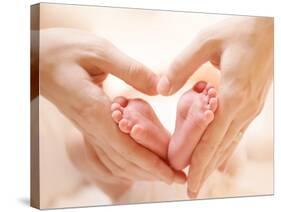 Baby Feet in Mother Hands. Tiny Newborn Baby's Feet on Female Heart Shaped Hands Closeup. Mom and H-Subbotina Anna-Stretched Canvas