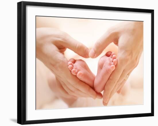 Baby Feet in Mother Hands. Tiny Newborn Baby's Feet on Female Heart Shaped Hands Closeup. Mom and H-Subbotina Anna-Framed Photographic Print