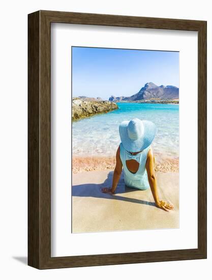 Back view of woman contemplating the sea sitting on pink sand of Falassarna beach-Roberto Moiola-Framed Photographic Print