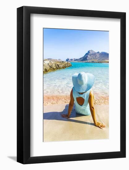 Back view of woman contemplating the sea sitting on pink sand of Falassarna beach-Roberto Moiola-Framed Photographic Print