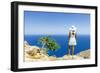 Back view of woman with fashion dress and hat looking at the sea from cliffs, Crete-Roberto Moiola-Framed Photographic Print