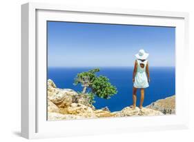 Back view of woman with fashion dress and hat looking at the sea from cliffs, Crete-Roberto Moiola-Framed Photographic Print