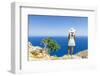 Back view of woman with fashion dress and hat looking at the sea from cliffs, Crete-Roberto Moiola-Framed Photographic Print