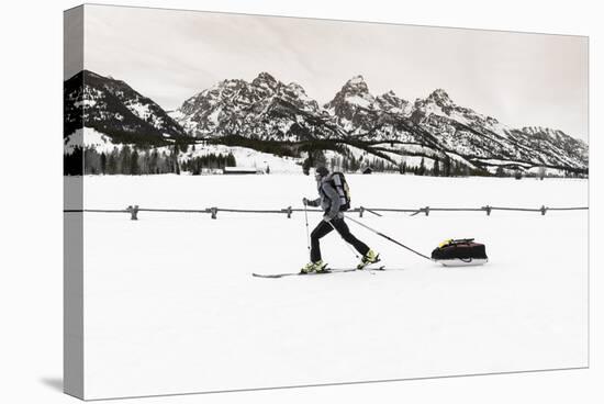 Backcountry skier under the Tetons, Grand Teton National Park, Wyoming, USA-Russ Bishop-Stretched Canvas