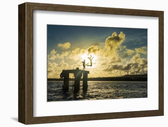 Backlit local boys jumping into the water of the lagoon of Wallis from a platform, Wallis and Futun-Michael Runkel-Framed Photographic Print