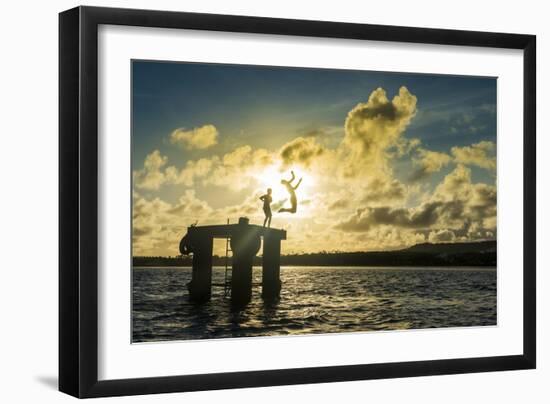 Backlit local boys jumping into the water of the lagoon of Wallis from a platform, Wallis and Futun-Michael Runkel-Framed Photographic Print