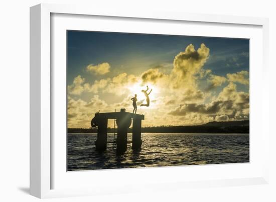 Backlit local boys jumping into the water of the lagoon of Wallis from a platform, Wallis and Futun-Michael Runkel-Framed Photographic Print