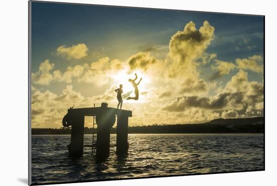 Backlit local boys jumping into the water of the lagoon of Wallis from a platform, Wallis and Futun-Michael Runkel-Mounted Photographic Print
